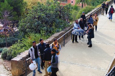 Barcelona, Spain-January 03,2016:Men from asian countries sale fake goods in the famous Parc Guell. Concept of illegal trade in streets of Barcelona. Immigrants sell counterfeit goods, fake products.