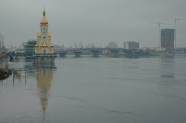 Kyiv, Ukrayna-16 Nisan 2023: Dnipro Nehri 'nin bahar seli sırasındaki geniş açılı şehir manzarası. Dinyeper Nehri seti boyunca suyun altındaki yol. Arka planda şehir manzarası. Kyiv 'de yüksek su.