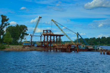 Nehir üzerinde yeni bir yaya köprüsü inşa etmek için çelik yapılar inşa etme süreci. Köprü inşa ediliyor. Ukrayna, Kyiv 'deki Obolon mahallesi.
