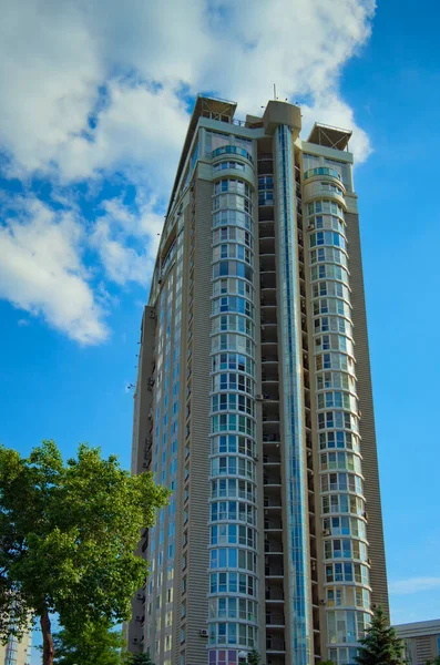 近代的な高層住宅の低角度ビュー 背景に白い雲と青空 ガラスとスチールからの近代的な建築 オボロン地区キエフにおける不動産の概念 — ストック写真