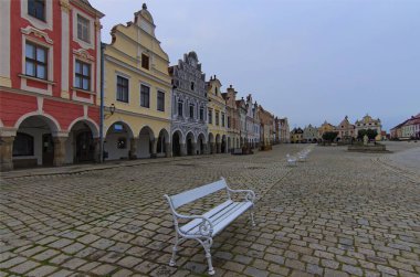 Çek Cumhuriyeti 'nin Telc kentindeki renkli rönesans binalarıyla antik pazar meydanının panoramik manzarası. Bulutlu bir yaz sabahı. Telc 'in ikonik simgesi. UNESCO Dünya Mirası Alanı.