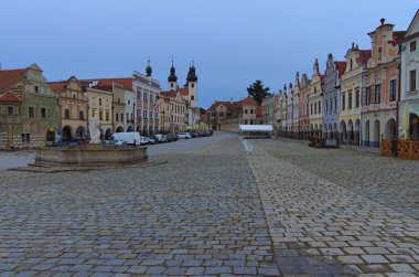 Çek Cumhuriyeti 'nin Telc kentindeki renkli Rönesans binalarıyla antik pazar meydanının geniş açılı manzarası. Bulutlu bir yaz sabahı. Telc 'in ikonik simgesi. UNESCO Dünya Mirası Alanı.
