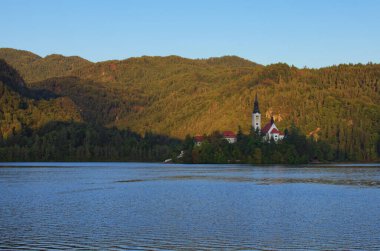 Sabah manzarası Bled Lake (Blejsko Jezero) ile küçük adada Maria 'nın Varsayımı Antik Hac Kilisesi. Dış seyahat arka planı.