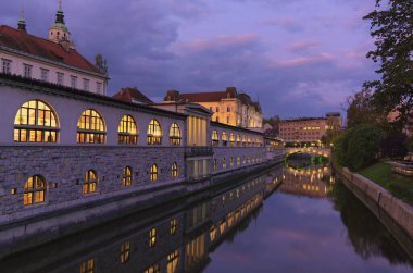 Eski şehir merkezi Ljubljana 'nın gündoğumu manzarası. Ljubljanica Nehri 'nin yanında renkli tarihi evler var. Tavel ve turizm konsepti.