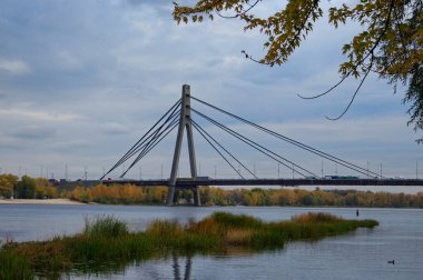 Ukrayna 'nın başkenti Kyiv' deki Dnipro Nehri üzerindeki manzara köprüsü. Pivnichnyi (Kuzey) köprüsü, kablo destekli Dnipro köprüsü. Büyük şehir konseptinin altyapısı. Güneşli bir sonbahar günü.