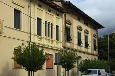 İtalya 'nın Tuscany, Pisa kentindeki ortaçağ binaları ve ağaçlarıyla tipik sokak manzarası. Avrupa 'nın ünlü turistik mekanı ve tatil beldesi.