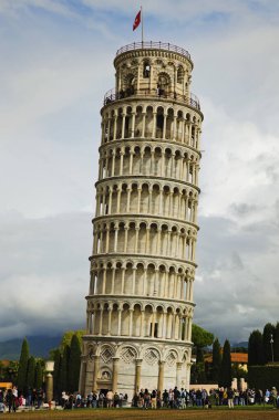 Fırtınalı gökyüzü ve kasvetli bulutlara karşı Ortaçağ Pisa Kulesi manzarası. İtalya, Pisa 'nın önemli bir simgesi. Seyahat ve turizm konsepti. UNESCO Dünya Mirası Alanı.