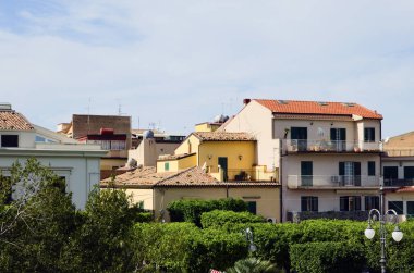 Mavi gökyüzüne karşı renkli konutların kırmızı kiremit çatılarının manzarası. Tipik Sicilya mimarisi. Santo Stefano di Camastra, İtalya. Seyahat ve turizm kavramı.