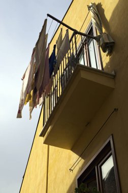 Tipik balkon görünümlü, renkli bir ön cephe. İç çamaşırları balkon çitinde kuruyor. Alt manzara. Castelbuono Köyü, Sicilya, İtalya.