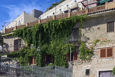 Panoramik manzara, yemyeşil sarmaşıklı eski taş ev. Taormina şehir merkezinde. Seyahat ve turizm kavramı.