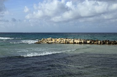 İtalya, Sicilya, Trapani yakınlarında soyut deniz manzarası. Bulutlu gökyüzüne karşı çeşitli deniz suyu renkleri. Ufukta büyük ticari gemi görünüyor..