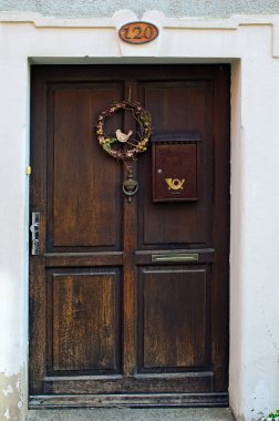 Posta kutusu olan ahşap kapılı ve çelenklerle süslenmiş kır evi beyaz duvarı. Madalyon, Çek Cumhuriyeti. Seyahat ve turizm kavramı.