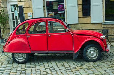 Kronach, Almanya-10 Nisan 2024: Kırmızı bir Citroen 2CV cadısı kaldırım taşı caddesinde park halinde. Iconic vintage Citroen 2CV. Fransız klasik arabası.. 
