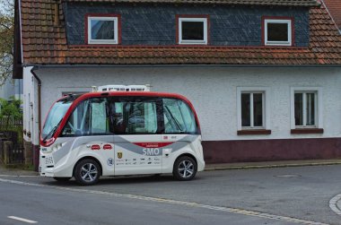 Kronach, Almanya-10 Nisan 2024: Kronach 'ta kendi kendine giden küçük bir elektrikli otobüsün ayrıntılı görüntüsü. Bavyera, Yukarı Franconia bölgesi, Almanya. Modern şehir otobüsünün ulaşım kavramı.