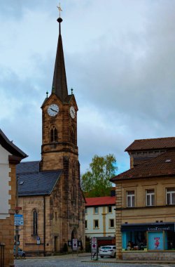Kronach, Almanya-10 Nisan 2024: Kronach 'taki İsa Kilisesi ile antik caddenin panoramik manzarası. İsa Kilisesi basit bir salon kilisesidir. Neo-Gotik taş bloklar şeklinde inşa edilmiştir..