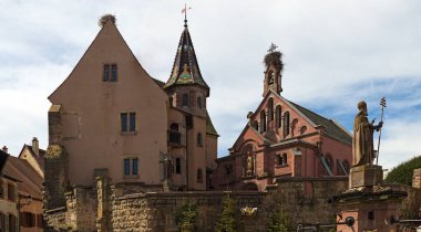 Eguisheim, Fransa 'daki Aziz Onbaşı Leon Chappel. Mavi gökyüzüne karşı antik binaların geniş açılı manzarası. Fransa 'nın kuzeydoğusundaki Alsace' de geleneksel mimari. Seyahat ve turizm kavramı.