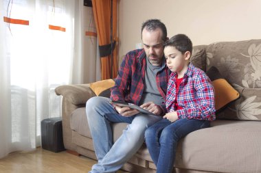 Baba oğul tablet kullanıyor.