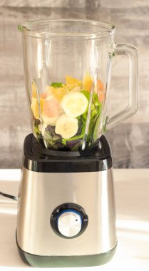 Tahta masada blender içinde taze sebze karıştırıcısı.