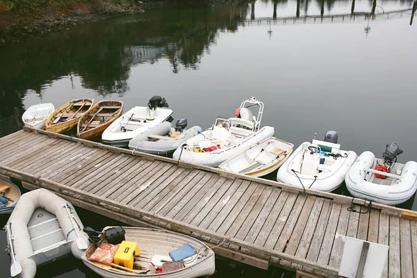 A view of several row boats and small motor boats docks in a local marina.