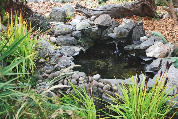 A view of a rock waterfall in a garden setting.