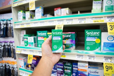 Los Angeles, California, ABD - 05-20-2022: Systane kayganlaştırıcı göz damlası paketini tutan el görüntüsü, yerel bir bakkalda sergileniyor.