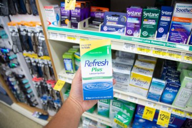 Los Angeles, California, ABD - 05-20-2022: Refresh Plus 'ın kayganlaştırıcı göz damlası paketini tutan bir elin görüntüsü, yerel bir bakkalda sergileniyor.