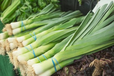 Yerel bir çiftçi pazarında sergilenen birkaç demet pırasa manzarası.