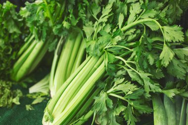 Yerel bir çiftçi pazarında sergilenen birkaç kereviz sapının görüntüsü.