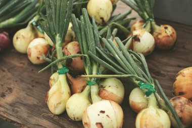 Sapındaki soğan yığını yerel bir çiftçi pazarında sergileniyor..