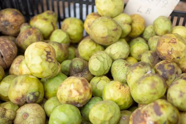 Yerel bir çiftçi pazarında sergilenen bir kasa Cherimoya meyvesi manzarası..