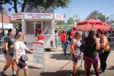 Garden Grove, California, ABD - 05-30-2022: Çilek Festivali 'nde çilekli kek ikram eden bir satıcının manzarası.