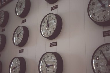 Long Beach, California, ABD - 05-20-2022: Long Beach adı verilen farklı şehirlerdeki zamanları gösteren birkaç analog saatin görüntüsü.