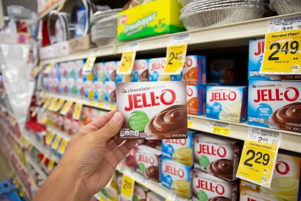 stock image Los Angeles, California, United States - 05-20-2022: A view of a hand holding a package of Jell-o chocolate pudding mix, on display at a local grocery store.