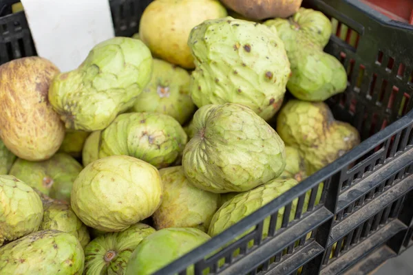 Yerel bir çiftçi pazarında sergilenen bir kasa Cherimoya meyvesi manzarası..