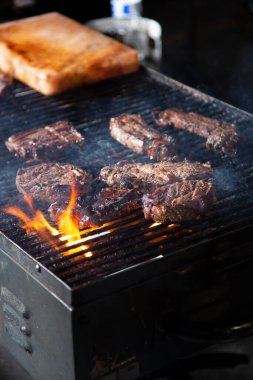 Izgarada pişen birkaç bifteğin görüntüsü.