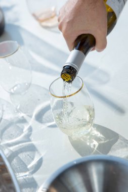 Bir bardağa şarap döken bir sunucunun görüntüsü.