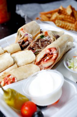 İçinde shawarma ambalajları olan bir başlangıç yemeği manzarası.