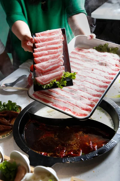 生牛と豚の切り身のプレートを提示サーバーの手のビュー 鍋料理の一部 — ストック写真