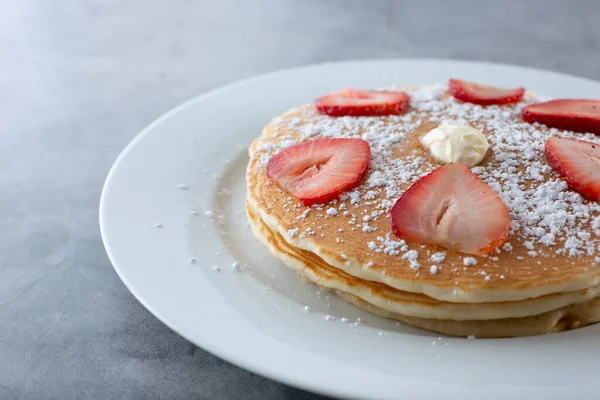 A view of a stack of pancakes on a plate.
