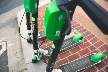 Los Angeles, California, Amerika Birleşik Devletleri - 03-10-2019: Kaldırımda kaldırıma kurulmuş birkaç Lime Electric Scooter kiralama aracı, biniciler için hazır, şarj edilmiş..