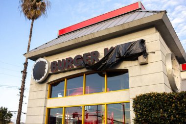 Los Angeles, Kaliforniya, ABD - 03-10-2019: Kapalı eski bir Burger King kalıntılarının manzarası, tabelası ve logosu plastik veya çöp poşetleriyle kaplı.