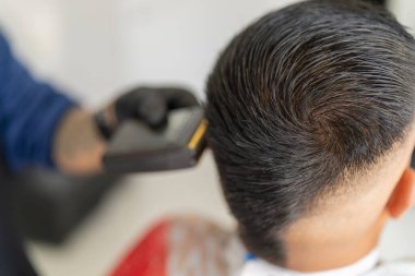 Berber onu tıraş ederken yeni görünüşlü bir adamın kafası.