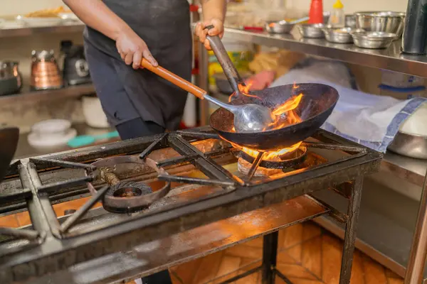 Peru restoranındaki bir tavada yanan malzemeler.