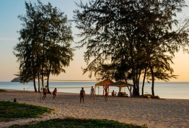 Birisiyle kumsalda voleybol oynuyor alacakaranlıkta, Phuket Tayland 'da