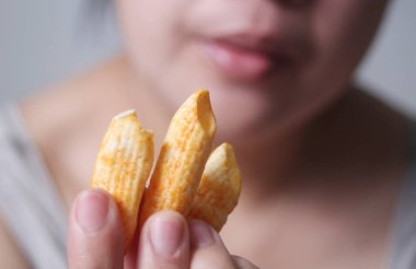 Yemek için gevrek mısır gevreği tutan kadın, Tayland, Çin, Laos, Vietnam ve Burma gibi Asya ülkelerinde yaygın olarak rastlanan lezzetli ve popüler bir sokak yiyeceğidir..