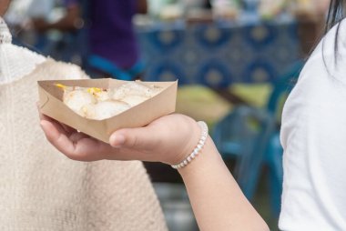 Tayland gözlemesi, kadınların ellerinde khanom krok geleneksel Tayland tatlıları. Tay insanları ve tüm dünyada turistler arasında popülerdir. Tayland sokak yemekleri.