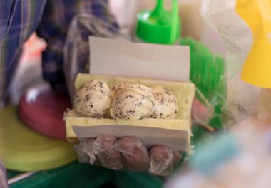 Erkek tüccarın elleri bir müşteri için vanilyalı çikolata parçalı dondurmayı ekmeğe batırıyor..