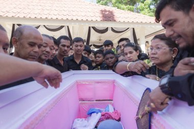 Phatthalung, Tayland - Nisan 05, 2024: Krematoryuma koymadan önce akrabalarına son bir kez bakmak için ölü bir kişinin tabutunu açmak