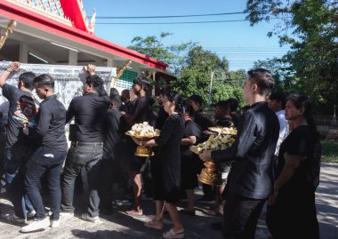 Phatthalung, Tayland... 5 Nisan 2024: siyahlı adam, ölülerin tabutlarını yakılmak üzere krematoryuma taşımaya yardım ediyor.