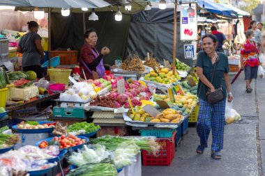 Suratthani, Tayland - 17 Nisan 2024: Yemek ve sebze almak için sokaklarda yürüyen insanlar, hem Tayland 'ın kırsal kesimlerinde hem de şehir merkezinde yol kenarında satılan sebzeler,